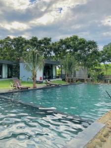 a large swimming pool with trees in the background at Mường Dy Retreat 2 in Ba Vì