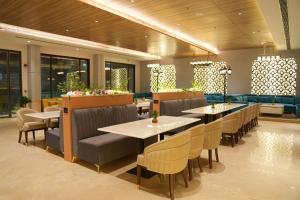 a restaurant with tables and chairs in a room at Comfort Inn Vindhyan, Vindhyachal in Mirzāpur