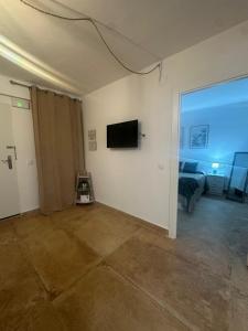 a room with a bed and a television on a wall at Arenas del Coliseo Parking Gratis in Merida