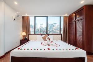 a bedroom with a large bed with roses on it at Thai Ha Hotel in Ha Long