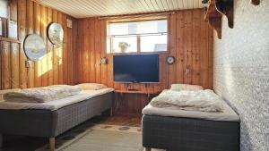 House near the sea and town centre in Skärhamn SE09107 في Nordvik: سريرين في غرفة مع تلفزيون على الحائط
