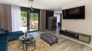 a living room with a blue couch and a tv at Villa Tea - Kremena by Villas Guide in Blace