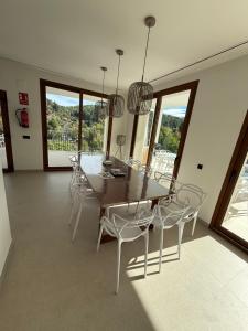 a dining room with a wooden table and chairs at Villa Raquel Montanejos in Montanejos