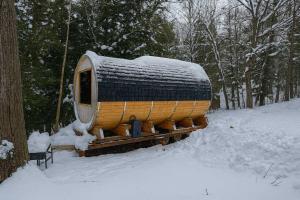 Una casa está cubierta de nieve en un tren. en Lakefront Barrel in Parry Sound #16, en Parry Sound