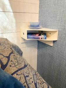Cottage By The Sea On Djurö في Djurhamn: رف كتب مع وعاء فوقه