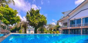a large swimming pool in front of a building at The Coco Grand Chalet in Satun