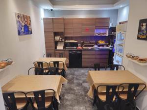 a room with two tables and a kitchen with a counter at Massilia hôtel in Marseille