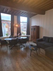 ein Wohnzimmer mit einem Tisch und einem Sofa in der Unterkunft Slapen bij De Buren in Alkmaar