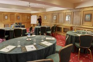 a woman standing in a room with tables and chairs at York Pavilion Hotel, BW Signature Collection by Best Western in York