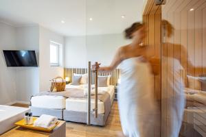 Eurostrand Resort Moseltal في ليوين: امرأة في غرفة بسريرين وحوض استحمام