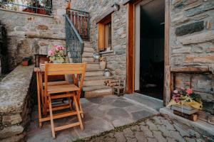 a wooden chair and a table in front of a house at Lo Chalet Du Village in Chambave