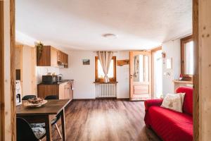a living room with a red couch and a table at Lo Chalet Du Village in Chambave +14 photos