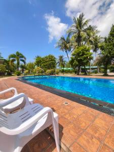 a white lounge chair next to a swimming pool at The Coco Grand Chalet in Satun +36 photos