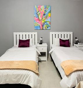 due letti uno accanto all'altro in una camera da letto di Ngwanase Properties a Durban