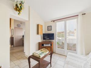 a living room with a couch and a table at Maison pour 4 avec jardin et véranda in Landevieille