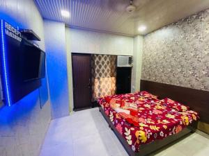 a bedroom with a bed and a flat screen tv at RS Hotel in Amritsar