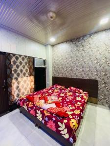 a bedroom with a large bed with a floral bedspread at RS Hotel in Amritsar