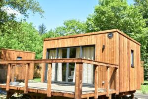 una casa di legno su una roulotte con alberi sullo sfondo di Le Hameau de l'Ourthe Houffalize a Houffalize