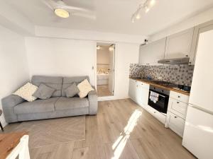 a living room with a couch and a kitchen at Casa Sirena in Estepona