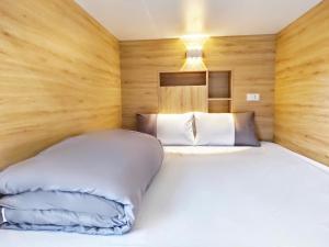 a bedroom with a large white bed with wooden walls at Lien Huong Hostel in Ha Giang