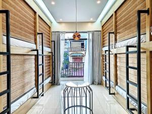 a room with three bunk beds and a stool in it at Lien Huong Hostel in Ha Giang