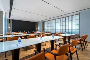 une salle de classe avec des tables, des chaises et un tableau noir dans l'établissement eLong Hotel Suzhou Guanqian Street, à Suzhou