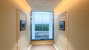 een gang met een raam met uitzicht bij Travinities Hotel Shree Ji Palace in Ujjain +28 foto's