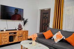 a living room with a couch and a flat screen tv at Darflings Haven-Diani in Ukunda