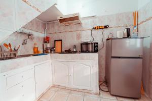 Family Guesthouse Dar Al Hajja Fatima في الرباط: مطبخ بخزائن بيضاء وثلاجة من الفولاذ المقاوم للصدأ +7 صور