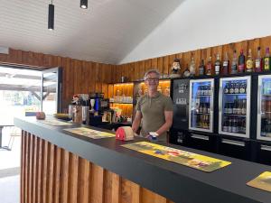 Un uomo in piedi al bancone in un bar di Le Hameau de l'Ourthe Houffalize a Houffalize