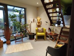 a living room with stairs and a yellow chair at B&B Aquavert in Tournai