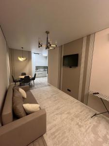 a living room with a couch and a table at Инжу Сити in Karagandy