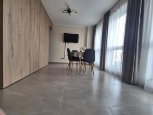 ein Esszimmer mit Tisch, Stühlen und Fernseher in der Unterkunft XTN house AIRPORT with PARKING in Cluj-Napoca