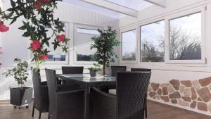 a dining room with a table and chairs and windows at Ferienhaus-Feinen in Lierfeld