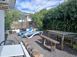 埃尔帕索Bungalow Los Guanches 2的天井配有桌椅和野餐桌。