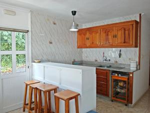 埃尔帕索Bungalow Los Guanches 2的厨房配有木制橱柜和凳子 更多11张照片