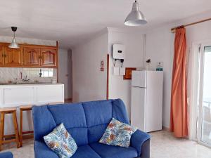 埃尔帕索Bungalow Los Guanches 2的带蓝色沙发的客厅和厨房