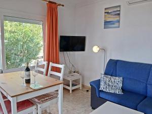 埃尔帕索Bungalow Los Guanches 2的客厅里有一张蓝色的沙发和一张桌子