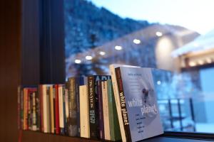 a row of books sitting on a book shelf at Piltriquitron Lodging in Sankt Anton am Arlberg