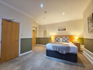 a bedroom with a large bed and a door at Derwent Manor Apartments & Rooms in Keswick