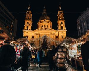 people walking around a christmas market in front of a building at Hotel Orion in Budapest