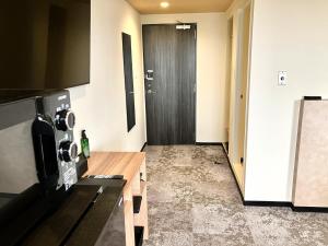 a room with a hallway with a black door at HOTEL LiVEMAX BUDGET Iyo Mishima in Shikokuchuo +25 photos