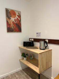 Bungalow Terra - Sarramea في Sarraméa: غرفة مع منضدة مع آلة صنع القهوة على رف