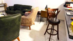 a living room with a couch and a table and chairs at Le Prestige Appartement à Oloumi in Libreville