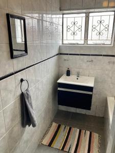 BelharUnit 1, TraversHub Sleeps 6 Self-Catering Group Belhar, CT的带水槽和浴缸的浴室