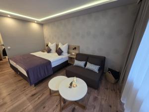 a bedroom with a bed and a couch and a table at TeMax Lux Hahnenklee in Goslar