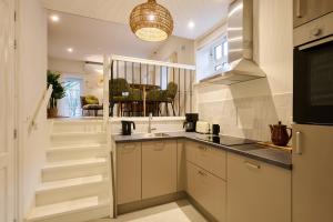 a kitchen with white cabinets and a sink at Appartement B Rosita in Twisk +15 photos