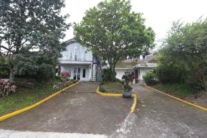 a white house with a tree in the driveway at Villa Gunung By ARBA in Pasakon 1