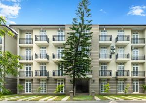 Un gran edificio con un árbol delante. en The Palace Gampaha by Axendra, en Gampaha