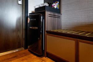 a black refrigerator in a kitchen next to a counter at Original Sokos Hotel Vaakuna Hämeenlinna in Hämeenlinna